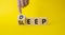 Deep Sleep symbol. Doctor points at wooden cubes with words Deep Sleep. Beautiful yellow background. Doctor Hand. Medicine and