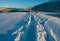 Deep snow trail path in sunlit alpine winter landscape in Wildermieming, Tirol, Austria