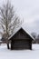 Deep snow, where you can see some trees and an old abandoned wooden building