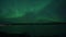 Deep strong aurora borealis, northern light over serene arctic fjord mountain