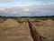 Deep trench cut in the dirt at construction site