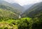 A deep valley in Neapal with mountaintops covered with clouds