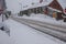 Deep winter snow covering pathways and burying cars.