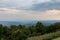 Deeply overcast view of the Blue Ridge Mountains of North Carolina, hazy atmosphere, rolling grass and tree line foreground