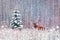 Deer male with big horns and lonely spruce tree in the winter snowy forest.