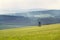 Deer stand, wooden hunters high seat hide on field, summer day, cloudy dramatic sky