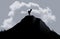 Deer stands atop a hill in this image silhouetted against a cloud i