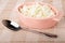 Defatted cottage cheese in pink bowl, spoon on checkered napkin