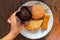 Deferent variety of snacks display on a plate a hand is holding chocolate muffin