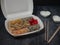 Defferent type of rolls or sushi set in a white plastic take-away box with chopsticks