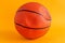 Deflated basketball ball on yellow background