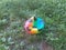 Deflated multicolored soccer ball on dirt and grass
