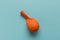 A deflated orange balloon on a blue background