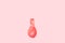 A deflated pink balloon on a pink background