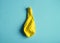 Deflated yellow balloon on blue background