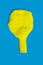 A deflated yellow balloon on a blue background