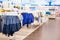 Defocus background, children`s clothing store and goods for children. Jackets and windcheaters on hangers, even rows of textile