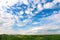 Defocus blue sky background with tiny white clouds and green meadow. Panorama blue sky background with clouds. Abstract
