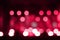 Defocus blurred abstract red bokeh background. Color of the year 2023. Viva magenta tint. Festive spotted glitter