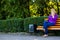 Defocus caucasian blond woman talking, speaking on the phone outside, outdoor. 40s years old woman in purple blouse in