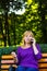 Defocus caucasian emotion blond woman talking, speaking on the phone outside, outdoor. 40s years old woman in purple