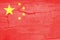 Defocus China flag, official colors and proportion correctly. National China flag. Stone wall background. Crack