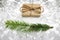 Defocus Christmas gift and green fir natural brunch on snowy background. Eco craft gift boxes. Organic eco craft