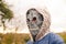 Defocus Halloween people portrait. Person in grim reaper mask standing on nature autumn background. Halloween horror
