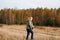 Defocus happy blond 40s woman walking in yellow autumn forest nature background. Happy beautiful lady. Side view. Women