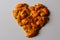 Defocus heart of dried orange and tangerine skins. On a gray background. Lots of small pieces of dried orange peel laid