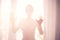 Defocus. High key light silhouette of a beautiful slender woman on the background of window