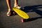 Defocus little urban girl standing with a yellow penny skateboard. Young kid in the park. City style. Urban kids. Trendy