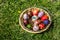 Defocus multicolored easter eggs. Decorated pysanka and krashanka. Wooden Basket With Easter Eggs In The Green Grass