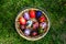 Defocus multicolored easter eggs. Decorated pysanka and krashanka. Wooden Basket With Easter Eggs In The Green Grass. Close-up.