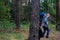 Defocus side view among trunk of two woman walking in pine forest. Mushroom picking season, leisure and people concept