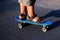 Defocus skater moving along asphalt road on a yellow skateboard wearing black sandals. Some of the legs are on a