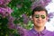 Defocus smiling man in circle sunglasses outdoors portrait. Spring people. Young men in purple shirt on nature summer