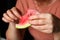 Defocus woman eating watermelon. Woman& x27;s hand holding slice of watermelon in home. Closeup female hands holding red
