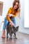 Defocus. Young business woman in a yellow blouse stroking her pet