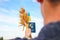 Defocus young man holding ukrainian passport, flag and wheat spikes of wheat tied and flag on the blue sky background