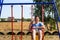 Defocus young man swinging on swing on playground. Countryside. Bright blue and red swing. Kids summer game. Guy have