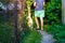 Defocus young man walking with a dog, siberian laika husky, in the village, countryside. Summertime, rear view. The pet