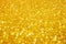 Defocused abstract colorful twinkle light background. Gold glittery bright shimmering background.