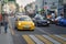 Defocused blured view of city street scene, urban traffic, yellow car before the pedestrian crossing next to the sidewalk Abstract