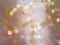 Defocused, Blurred, and Bokeh Gold Lights From A Sparkling Silky Fabric, Light Abstract for Background and Celebration Use