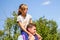 Defocused brother riding sister on back. Portrait of happy girl on man shoulders, piggyback. Girl fly. Family playing