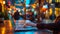 Defocused cityscape with a person typing on a laptop in a bustling outdoor cafe. The blurred lights and movement of
