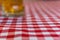 Defocused glass of beer on a chequered tablecloth