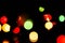 Defocused glowing shiny multicolored christmas lights on black