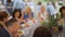 Defocused: Group of people celebrating and partying in tents outdoors chatting and eating